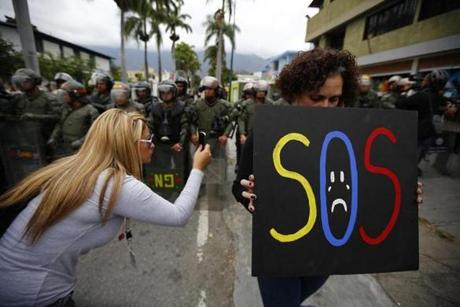 SOS sign held by Venezuelan protester